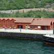 P010 ... souvenir shops, cafes and restaurants by the Flåm port, near the railway station by the Fretheim Hotel... road-tunnel on the hillside is the route E16...