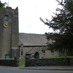 P006 ... St Oswald's Church, constructed in roughcast stone with slate roofs; its plan consisting of a double nave, with a south porch and a southwest tower - the...